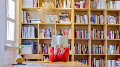 Woman reading a book in library.