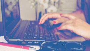 woman hands on keyboard with glasses