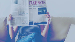 woman reading paper fake news